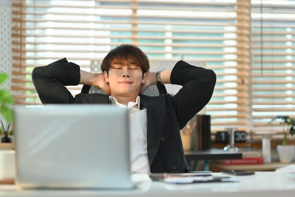 Relaxed businessman sitting on a high back office chair